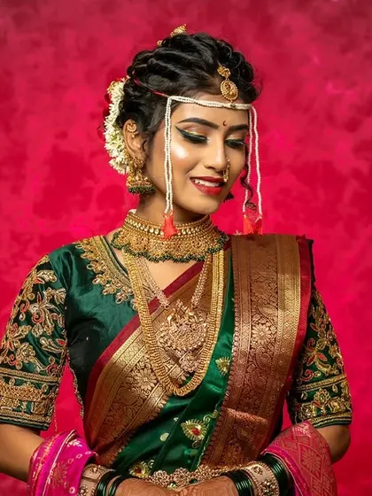 A beautiful pose from a Maharashtrian bride. The makeup is kept elegant and clean to complement the heavy traditional jewelry and the vibrant green and gold saree.