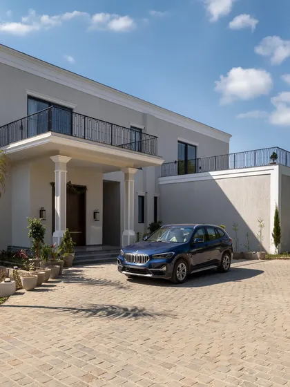 The arrival experience is the first chapter of a home's story. The paved driveway and stately entrance of this villa create a sense of occasion, welcoming residents and guests into a world of bespoke design.