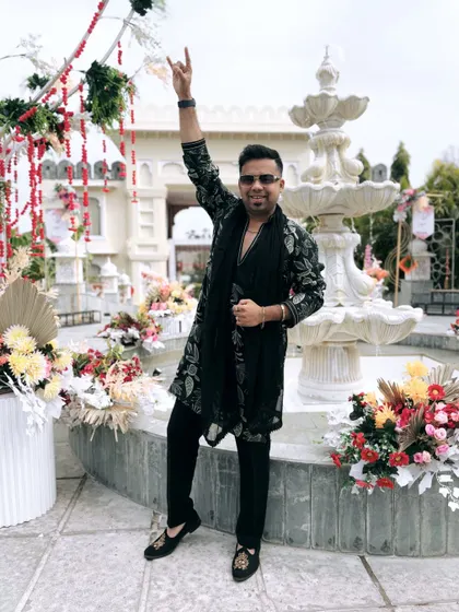 Rock on! In front of a beautiful palace-like venue, I'm ready to welcome the groom's Baaraat with high energy and a whole lot of noise.