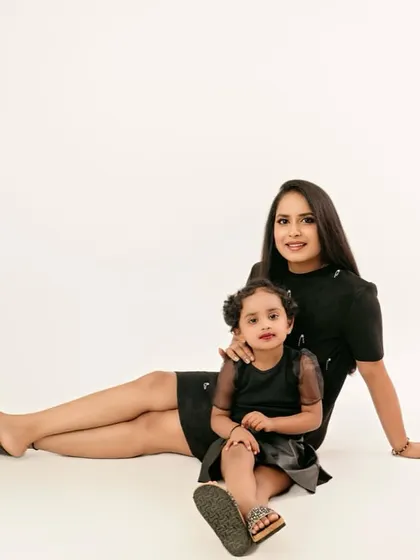 Simple, clean, and elegant. A mother and daughter in matching black dresses against a pure white backdrop creates a striking, high-fashion look that is both modern and timeless.