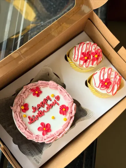 A classic birthday gift box featuring a pretty pink bento cake with a "happy birthday" message and two matching cupcakes. I can customize the colors and floral designs to whatever you like.