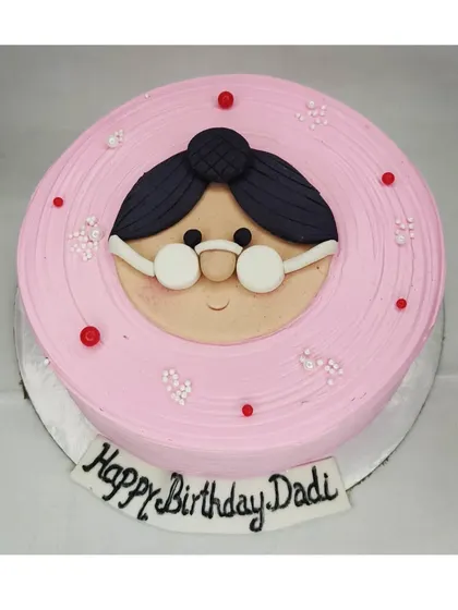 A special cake for a grandmother's birthday. This mixed fruit cake features a cute, handmade fondant face of a "Dadi" with glasses.