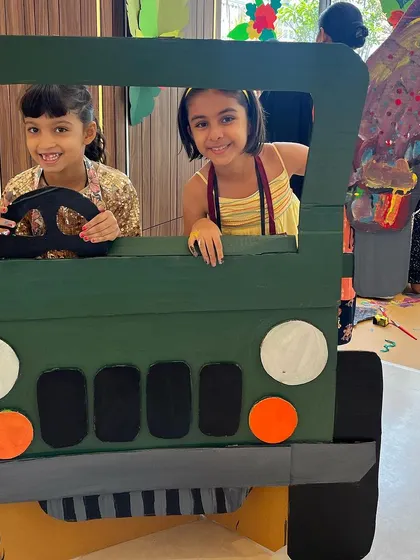 After creating a jungle, you need a jeep to explore it. Here, two friends are ready for an imaginative safari in a cardboard jeep they helped create. Our workshops go beyond painting; we build worlds and then play in them, sparking storytelling and creative play.