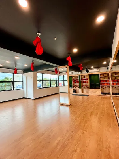 The spacious hall at our Hamsa Learning Centre, with aerial silks ready for practice. The large windows fill the room with natural light, creating an ideal learning environment.