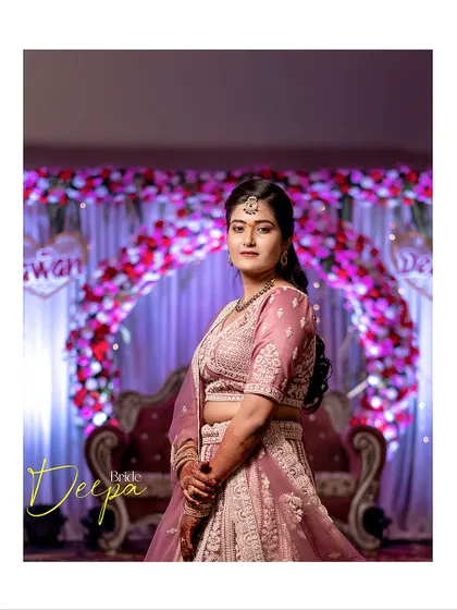 A classic portrait of the bride standing before the floral arch at her wedding venue, capturing her in the context of her beautifully decorated event.