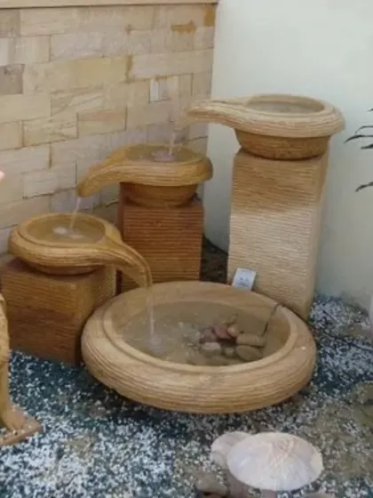 A multi-tiered, stone-finish water fountain feature, ideal for creating a serene and relaxing focal point in a garden or courtyard.