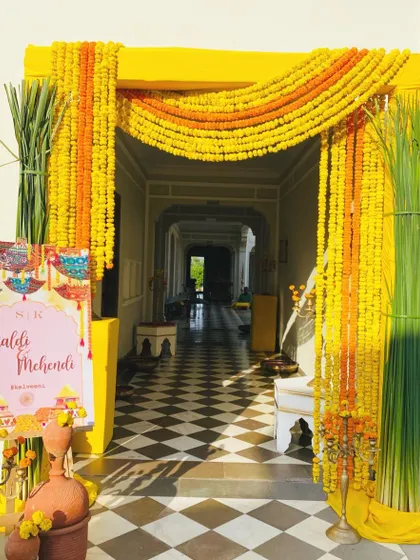 The energy of a Haldi ceremony starts at the entrance. I used bold yellow framing and dense strings of traditional marigolds to create a vibrant and joyful welcome that sets the tone for the fun-filled event ahead.