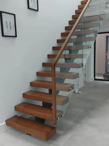 This centre-spine staircase creates a floating effect, using a single steel support and solid oak treads. The design keeps the hallway bright and open.