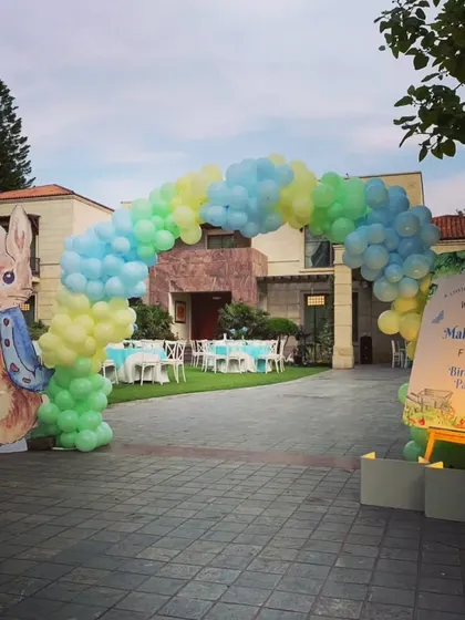 The entrance to the Peter Rabbit party, with a colorful balloon arch and a character cutout welcoming guests to Mahad's first birthday.