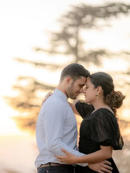 An intimate portrait of a couple at sunset. The warm, soft light and their close embrace create a deeply romantic and timeless image.