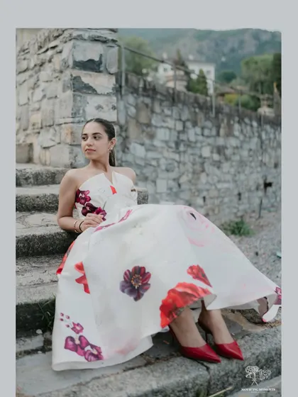 A beautiful portrait of the bride sitting on stone steps in Italy. Her floral dress and elegant pose create a look that is both fashionable and timeless.