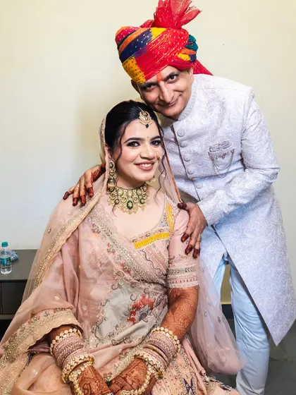 A heartwarming photo of the bride with her father, a precious family moment.