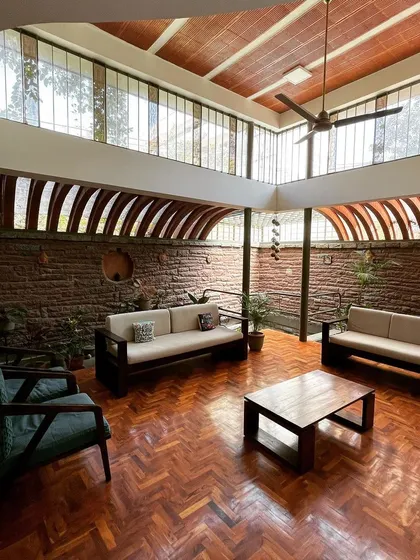 Is it a living room or a room filled with life? With its high, arched windows, exposed brick walls, and views of the surrounding greenery, this space is designed to be a breathable, light-filled family area.