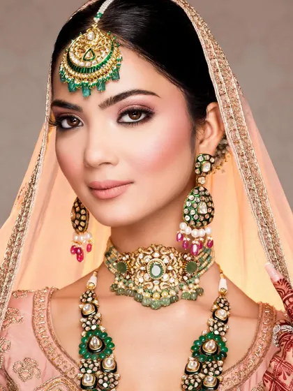 A classic beauty shot of the bride, with the dupatta gently framing her face. The focus is on her flawless makeup and the magnificent statement jewelry, capturing a look of pure grace.