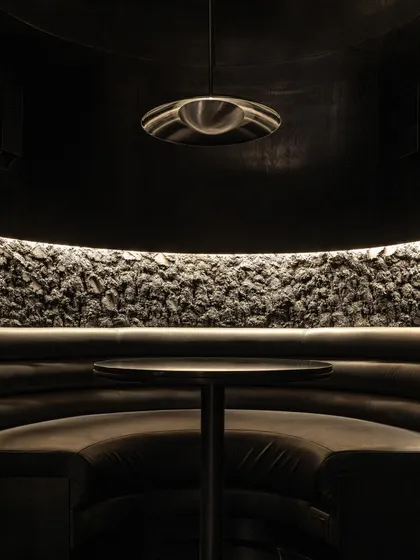 Details of the seating at Lair, where rough, rock-like textures meet smooth leather upholstery. This tactile contrast is central to the bar's sensory narrative.