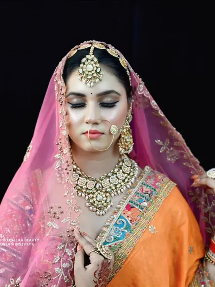 The sheer pink dupatta adds a layer of softness to this vibrant look. The makeup remains visible and radiant, perfect for photos with and without a veil.