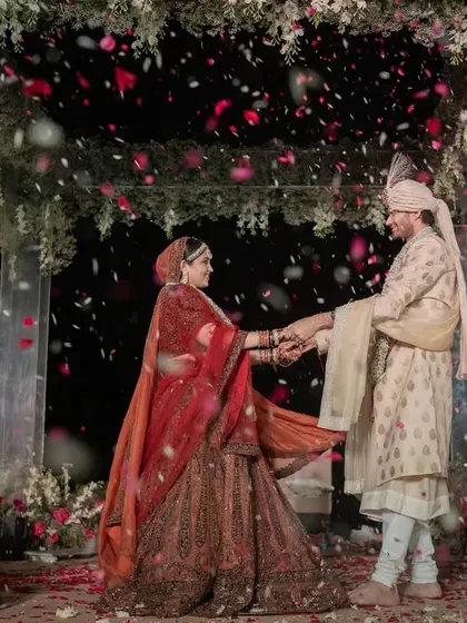 A beautiful moment as the couple exchanges vows under a canopy of flowers, with petals showering down on them. This is the kind of romantic, picture-perfect scene I strive to create.