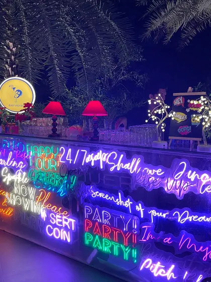 Our custom neon bar, shown here at a private birthday party. The bright, colorful signs are fully customizable to match your event's theme or display a special message for your guests.