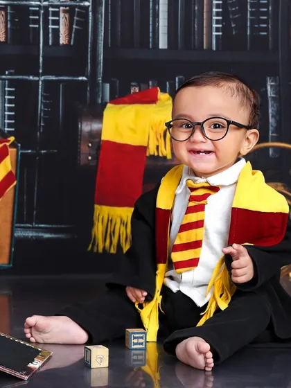 With a cheerful, toothy grin, this little wizard is pointing out something magical. The costume and props make for an authentic and adorable portrait.