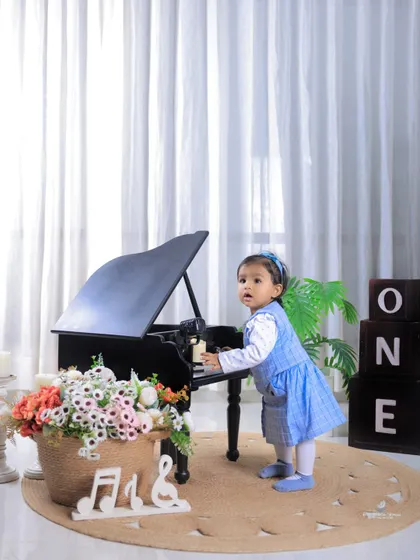 Another angle of our popular piano setup, capturing a candid moment as the birthday girl explores the miniature instrument.
