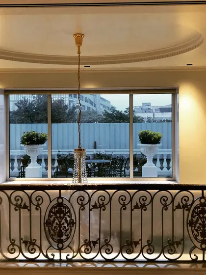 A classic French style terrace garden with white marble planters and outdoor seating. The elegant design looks stunning, even when viewed from inside the house.