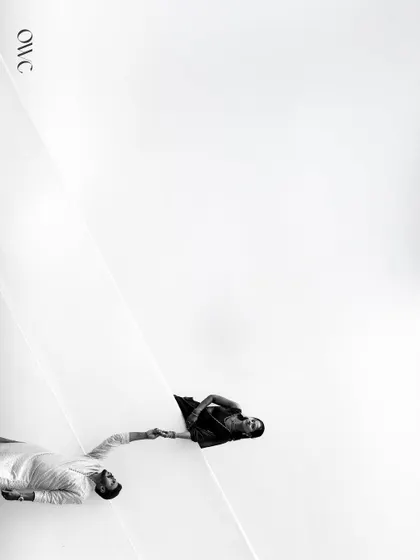 A creative black and white photo using strong diagonal lines and negative space to create a unique and artistic couple portrait.