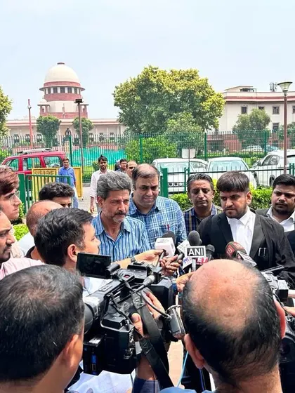 Surrounded by media after a significant hearing at the Supreme Court. Handling high-profile cases requires managing both the legal battle and the public narrative.