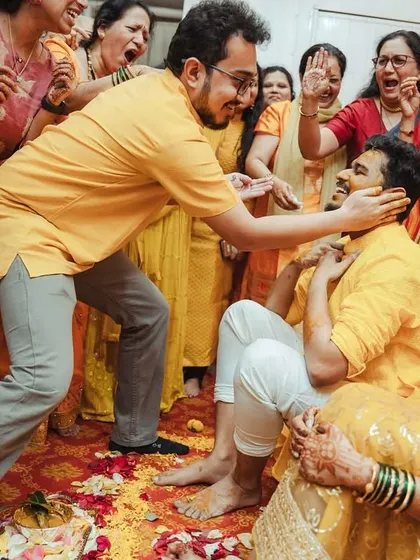 The groom gets a loving but firm Haldi application from his friends and family, a classic moment of wedding chaos.