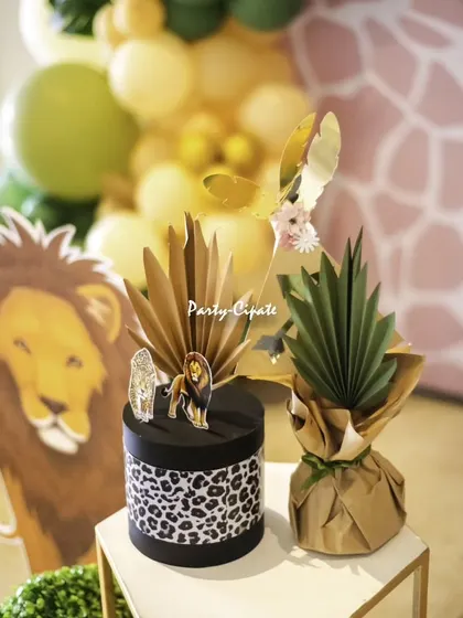 The little details make the theme. For this safari party, we created custom table props, including a leopard-print box and paper-craft pineapples, to enhance the jungle vibe.