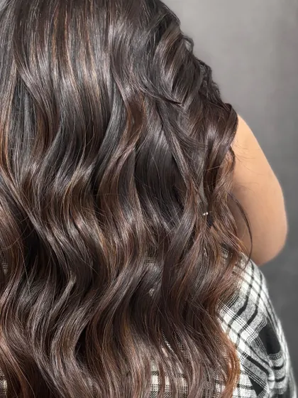 A close-up of the glossy waves, showing the health and shine of the hair.