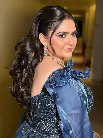 A look at the elegant hairstyle from the back. The soft, voluminous curls add a touch of Hollywood glamour to her reception look.