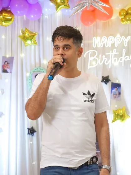 A close-up shot of me on the mic, with the beautiful birthday decorations in the background.
