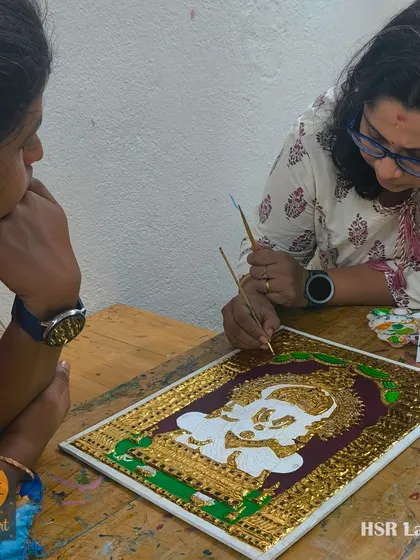 A student carefully observes as I demonstrate a fine-lining technique on a Ganesha Tanjore painting. We focus on passing down the authentic methods of this classic art form.