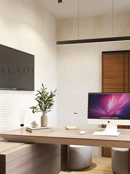 A close-up of the executive desk area, showcasing the clean lines of the furniture, integrated technology, and a sculptural wall texture illuminated by pendant lighting.