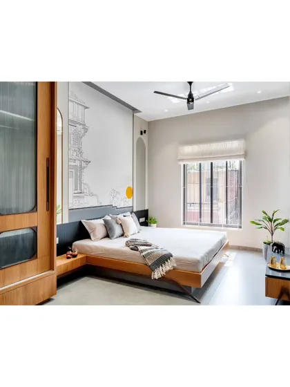A minimalist bedroom design with a low platform bed and a custom wooden wardrobe with fluted glass panels.