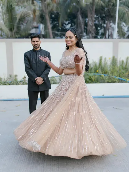 A fun, twirling shot that shows off the movement of the lehenga. Her radiant smile and glowing makeup complete this perfect engagement moment.
