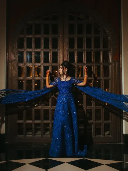 For Shree's sangeet, we customized this royal blue gown from a Middle Eastern designer. The flowing cape sleeves add a touch of drama, perfect for a grand entrance.