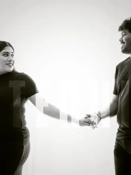 A modern and artistic black and white portrait. The couple holds hands, with the word "MATERNITY" overlaid, creating a stylish and memorable announcement-style photo.