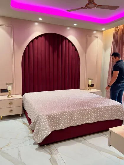 This view captures the dramatic effect of the pink ceiling lights against the deep red headboard.