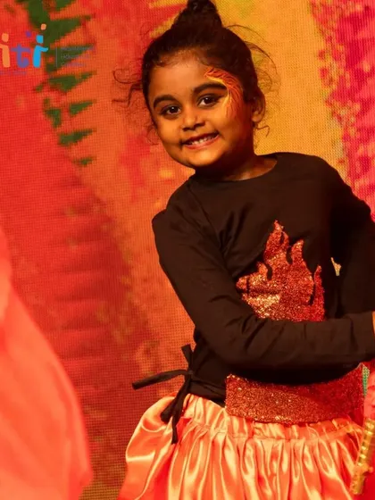 A smiling performer enjoys her moment on stage during the Agni dance. The goal is always for the children to have a positive and joyful experience.