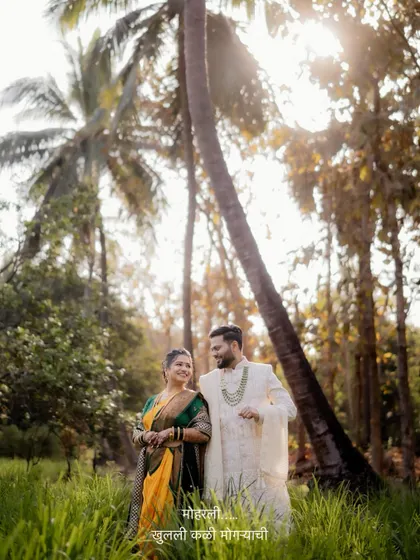 A stunning wide shot of the couple standing amidst palm trees, capturing the beauty of the natural landscape in their wedding portraits.