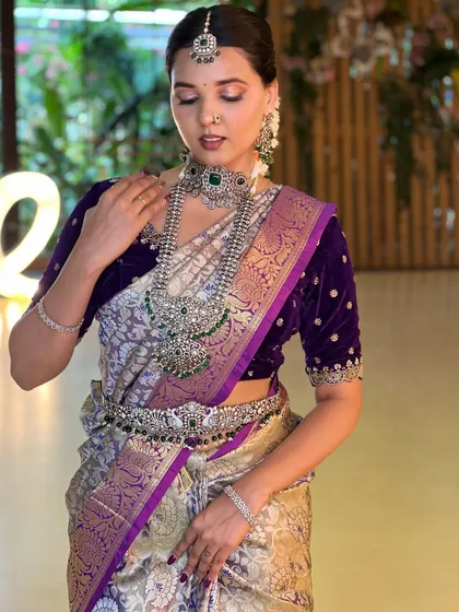 The rich purple of the velvet blouse is a beautiful backdrop for the sparkling jewellery. This set includes a choker, a long necklace, and a matching vaddanam.
