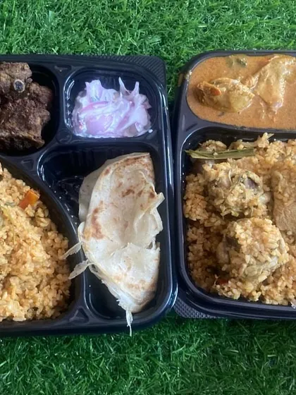 Biryani, boiled egg, bread and non-veg sides fill our compartment meal boxes, with onion raita packed alongside.