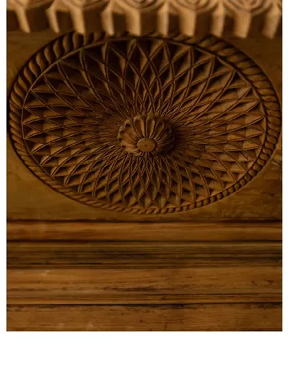 A close-up of the intricate carving on a repurposed wooden element. These details carry stories of craftsmanship and time.