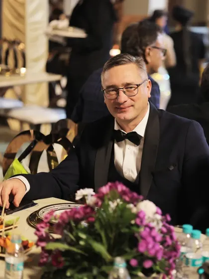 Dressed in a tuxedo, a guest enjoys his meal at an elegant table setting. This image reflects the high-end, formal events that we are equipped to handle.