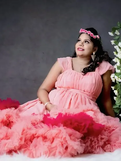 This client chose a stunning pink and red layered ruffle gown for her indoor maternity studio shoot. The vibrant colors and textures make for a truly unique look.