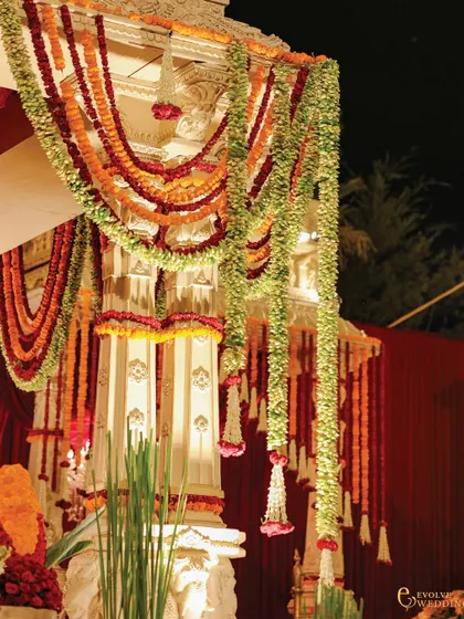 A close-up of the traditional floral garlands, or 'haars', adorning the mandap pillars. This showcases the use of authentic, handcrafted elements to bring heritage to life.