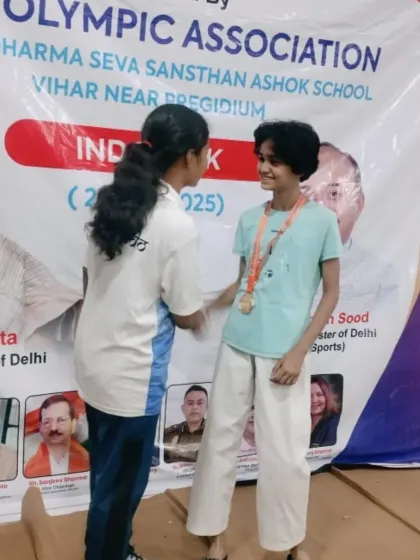 A moment of sportsmanship and celebration between teammates at the Delhi Olympic Games. Our academy is built on a foundation of mutual respect.