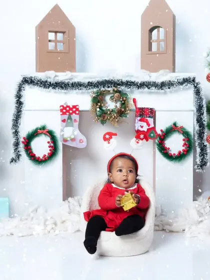 A tiny Santa sitting in a chair, surrounded by a winter wonderland of snow and Christmas decorations.