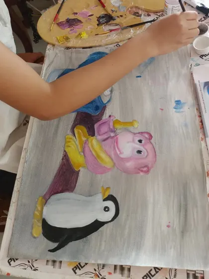 Our oil painting classes are perfect for kids who love to bring their favorite characters to life. Here, a young student carefully paints a colorful cartoon scene, learning about blending and composition.
